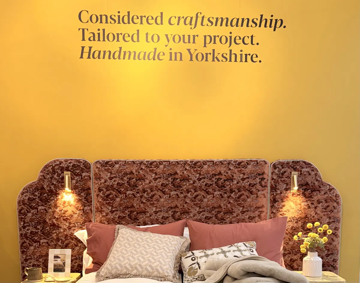 Upholstered velvet headboard with built-in brass reading lights by The Odd Company, handmade in Yorkshire, at Decorex 2026